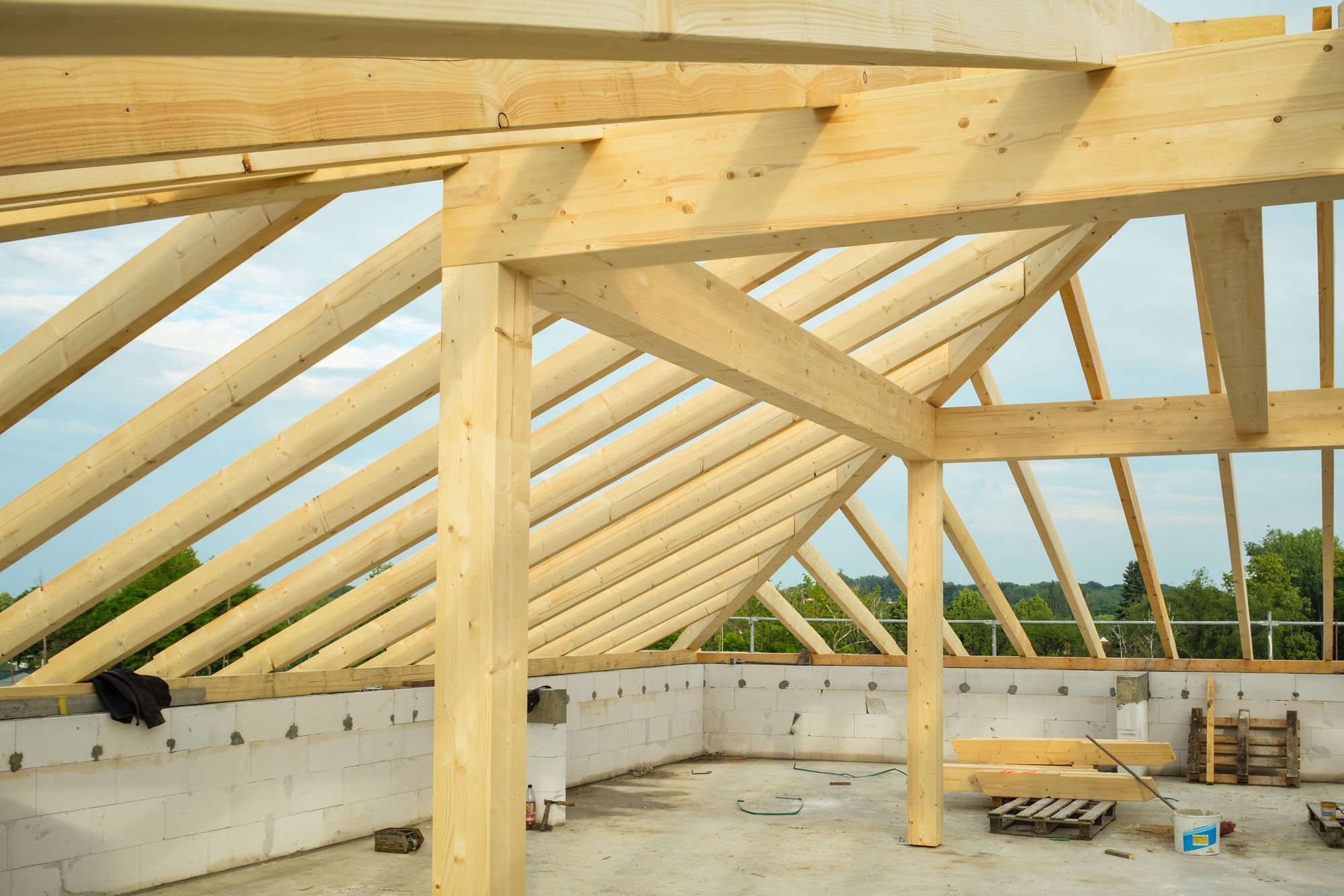 Heller Dachstuhl aus Holz auf der Rohbauschale eines Einfamilienhauses bei Tageslicht